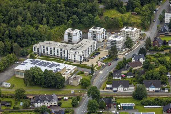 Aerial view, construction site with new urban villas and flats, on the site of the former secondary school, sports hall and railway line with level crossing, Gennersbach, Bad Laasphe, Wittgensteiner Land, North Rhine-Westphalia, Germany, architecture, outdoor area, railway line, level crossing, construction work, construction site, village, development, development, progress, building, terrain, real estate, infrastructure, construction, landscape, landscaping, new construction, summer, sports hall, city view, urban planning, urban villas, daylight, technology, urban, residential area, residential building, flats, clouds, German city, former secondary school, modern architecture
