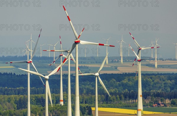 Aerial view, wind park and wind farm wind energy plant, wind turbines and rape fields near Radlinghausen, Messinghausen, Brilon, East Westphalia, Sauerland, North Rhine-Westphalia, Germany, wind park, wind farm, wind energy plant, wind turbines, rape fields, Radlinghausen, renewable energy, landscape, agriculture, sustainability, technology, environment, fields, green, yellow, sky, clouds, bird's eye view, infrastructure, energy production, rural, modern, nature, spring landscape, clean energy