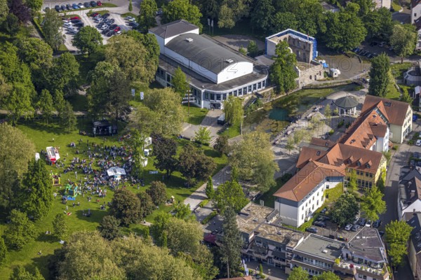Aerial view, Congress Centre Bad Lippspringe, Arminius Park with castle ruins and river Lippequelle and Arminius Quelle Pavilion, Father's Day celebration in Arminius Park at the Congress Centre, visitors on the meadow, bouncy castle and drink stands, Bad Lippspringe, East Westphalia, North Rhine-Westphalia, Germany, Congress Centre, Arminius Park, castle ruins, river, Lippequelle, Arminius Spring Pavilion, Father's Day festival, visitors, meadow, bouncy castle, drinks stands, park, celebration, people, family, children, adults, leisure, entertainment, culture, nature, green space, trees, riverbank, architecture, historical, event, outdoors, daylight, spring, summer, joy, community, recreation, landscape