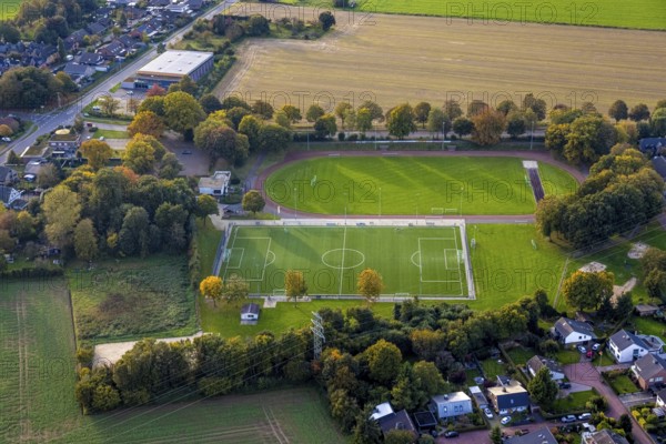 Aerial view, sports field and football stadium SV 1923/27 e. V. Bedburg-Hau, above the Dietmar Müller sports hall, Hau, Bedburg-Hau, Lower Rhine, North Rhine-Westphalia, Germany, sports field, football stadium, SV 1923/27, Dietmar Müller sports hall, architecture, facility, sport, building, exterior view, green area, grandstand, playing field, town, region, leisure, sports facility, infrastructure, landscape, sky, residential area, trees, street, car park, daylight, structural, recreation, recreational facility