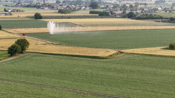 Agricultural irrigation system spraying water on a soybean field during springtime in Italy's fertile Po valley showcasing modern farming techniques for crop cultivation and water management