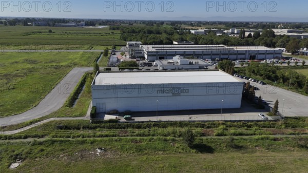 Cremona, Italy August 22nd 2025 Aerial view of the MicroData Group data center building, prominently situated among green fields, supporting cloud storage and data management