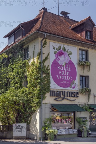 Overgrown façade with floral decorations and advertising poster, Dornbirn, Vorarlberg, Austria
