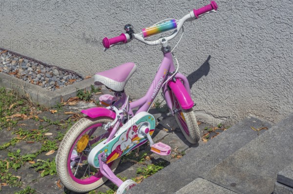 Pink-coloured Unicorn children's bike with training wheels, Dornbirn, Vorarlberg, Austria