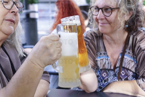 Women enjoying refreshing beer at a pub, celebrating friendship