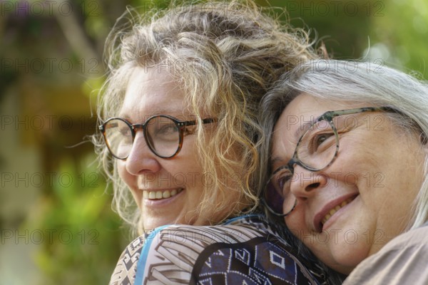 Two happy senior women are hugging each other outdoors, enjoying a moment of affection and togetherness celebrating their love and lgbtq pride