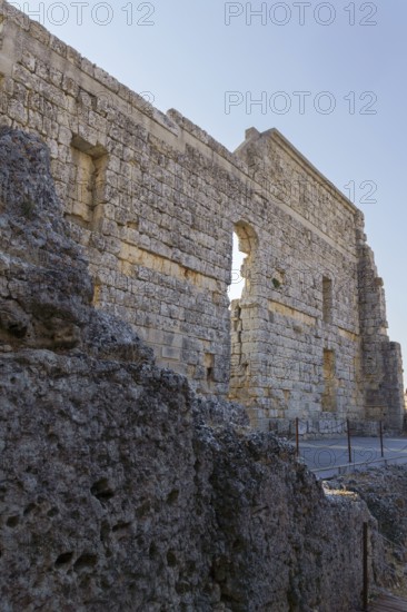 08/21/2025 Ronda, Malaga, Spain Main facade of the ruins of the Roman amphitheater of Acinipo with a blue sky in the background