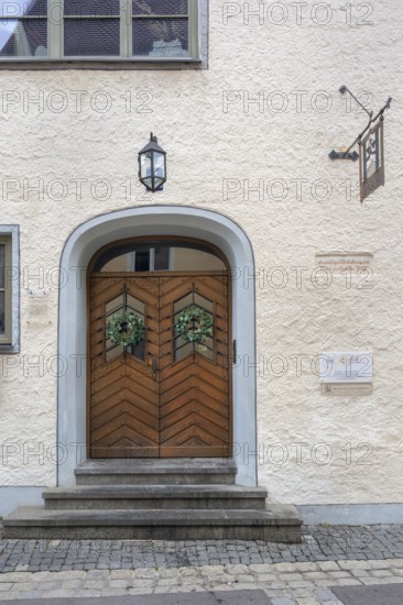 Façade with wooden gate, lantern and ivy wreaths, former residence of the patrician Vogt family, Kempten, Allgäu, Bavaria, Germany