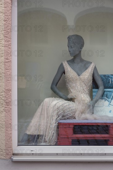 Shop window with grey fashion mannequin in evening dress, Bavaria, Germany