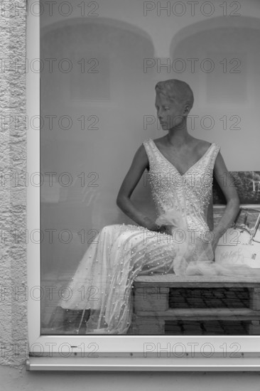 Shop window with grey fashion mannequin in evening dress, Bavaria, Germany