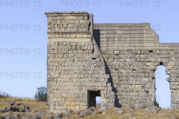 08/21/2025 Ronda, Malaga, Spain Main facade of the ruins of the Roman amphitheater of Acinipo with a blue sky in the background