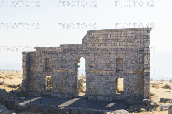 08/21/2025 Ronda, Malaga, Spain Main facade of the ruins of the Roman amphitheater of Acinipo with a blue sky in the background
