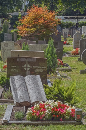 Gravesite with stone book and floral decoration, catholic cemetery, Kempten, Allgäu, Bavaria, Germany