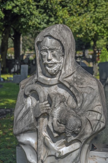 Gravesite with stone figure, the good shepherd with lamb catholic cemetery, Kempten, Allgäu, Bavaria, Germany