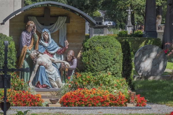 Gravesite with depiction of the Descent from the Cross and floral decoration, Catholic cemetery, Kempten, Allgäu, Bavaria, Germany
