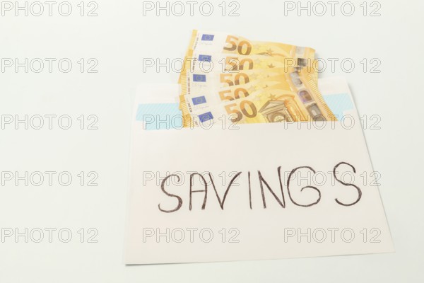 Euro banknotes in an envelope labeled savings illustrating the concept of personal finance and money management