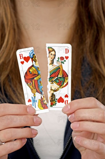 Woman holding a torn playing card in her hand