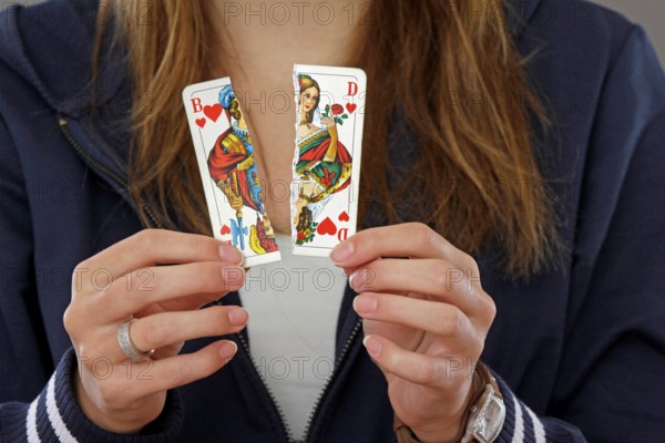 Woman holding a torn playing card in her hand