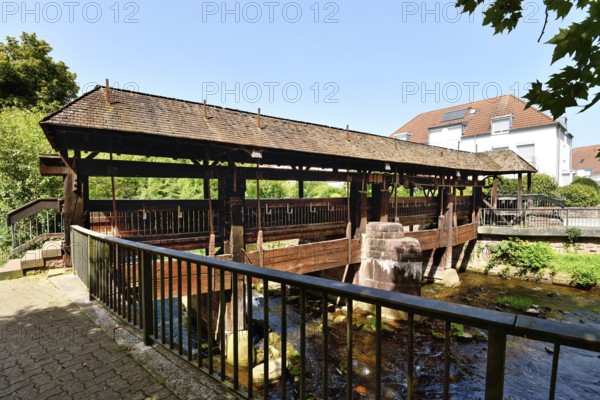 Ettlingen, Germany - August 13th 2025: Old wooden bridge over the Alb river. Historic landmark on a sunny day