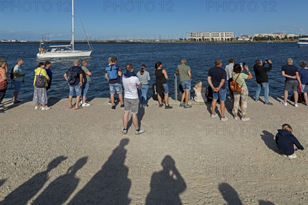 People waiting for the departure of the Aida mar, shadow, sailing boat, Unterwarnow, Warnemünde, Rostock, Mecklenburg-Vorpommern, Germany