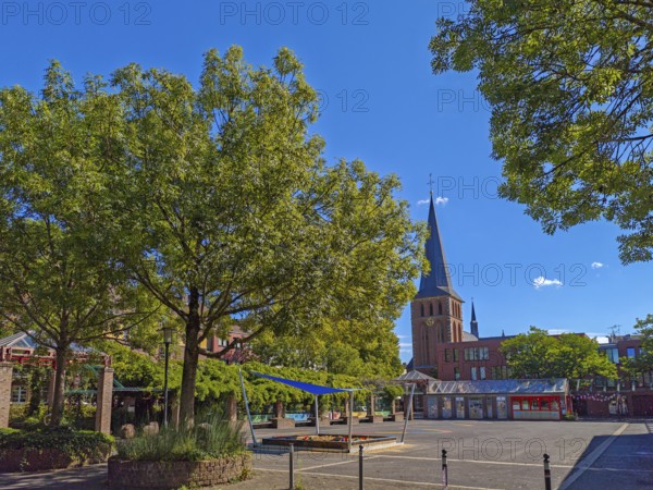 Old town with catholic church St. Margareta, brick building, architecture, square with sandpit, trees, blue sky, sunshine, religion, Brühl, North Rhine-Westphalia, Germany