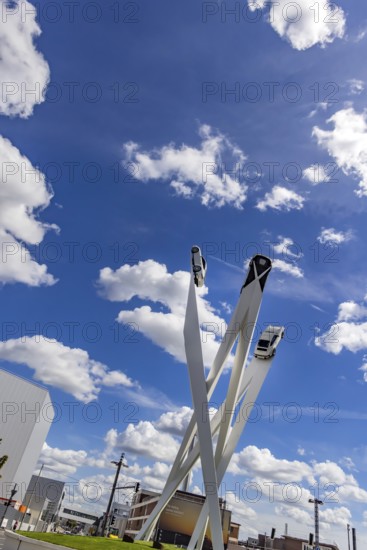 Stuttgart Zuffenhausen with headquarters and logo. Inspiration 911 artwork by Gerry Judah on Porscheplatz: three pillars, each up to 24 metres high, presenting a Porsche 911. Stuttgart, Baden-Württemberg, Germany