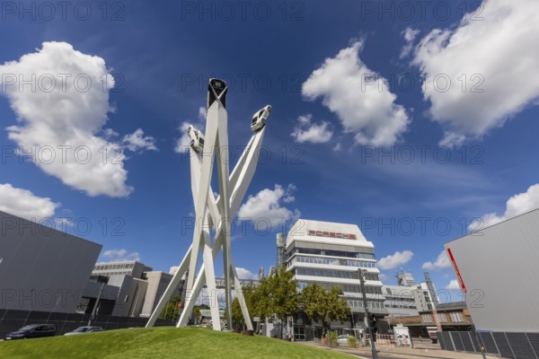Stuttgart Zuffenhausen with headquarters and logo. Inspiration 911 artwork by Gerry Judah on Porscheplatz: three pillars, each up to 24 metres high, presenting a Porsche 911. Stuttgart, Baden-Württemberg, Germany
