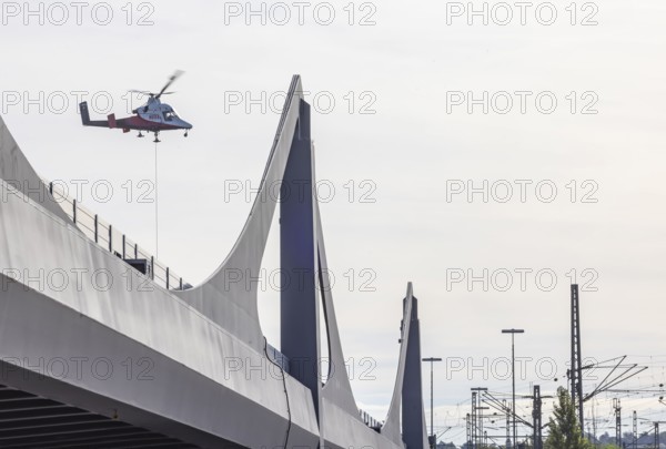 Track construction from the air. At Bad Cannstatt railway station, a transport helicopter transports 26 catenary masts to their destination. The masts, weighing up to 2.4 tonnes, were delivered by rail. The reason for this is to improve the infrastructure as part of the Stuttgart 21 project. Stuttgart, Baden-Württemberg, Germany