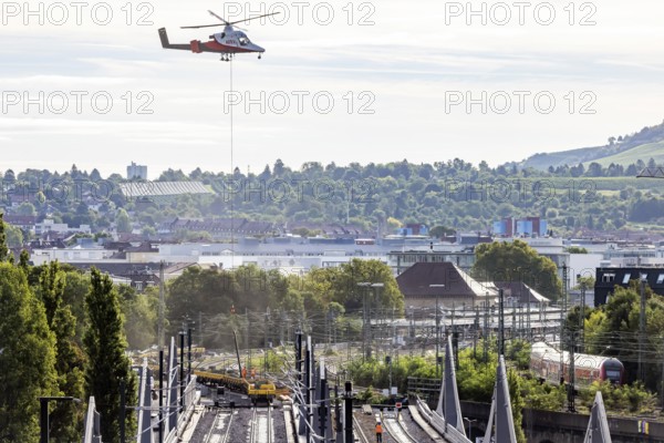 Track construction from the air. At Bad Cannstatt railway station, a transport helicopter transports 26 catenary masts to their destination. The masts, weighing up to 2.4 tonnes, were delivered by rail. The reason for this is to improve the infrastructure as part of the Stuttgart 21 project. Stuttgart, Baden-Württemberg, Germany