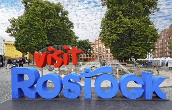 Vist Rostock logo, behind it fountain of joie de vivre, behind it university, university square, harbour city, Hanseatic city, university city, Rostock, Mecklenburg-Western Pomerania, Germany