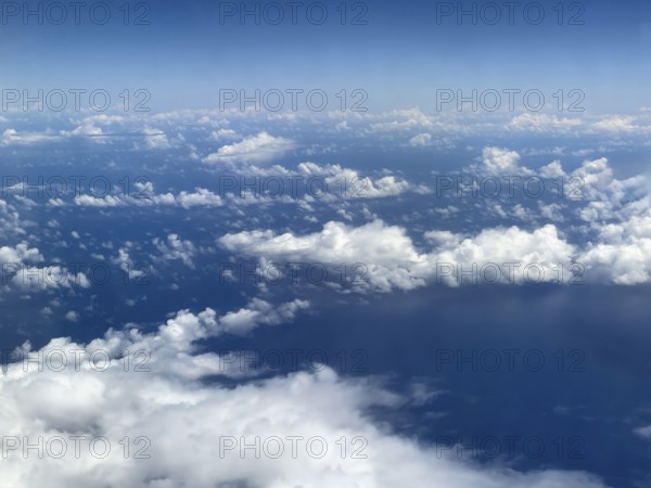 Aerial view from aeroplane at high altitude of white, bright cluster clouds Altocumulus, international