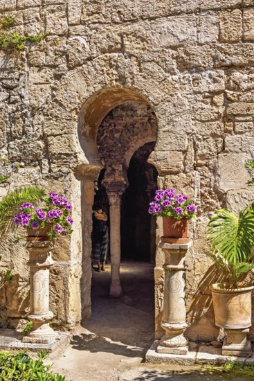 Flowers on pedestals at an opening into the Arab baths old building with oriental architecture, Palma de Mallorca, Mallorca, Spain