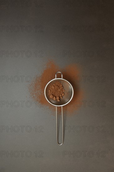 Kitchen sieve with cocoa powder, cocoa