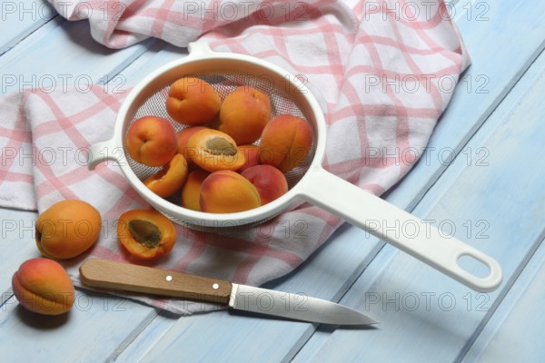 Apricots in colander, halved, Prunus armeniaca