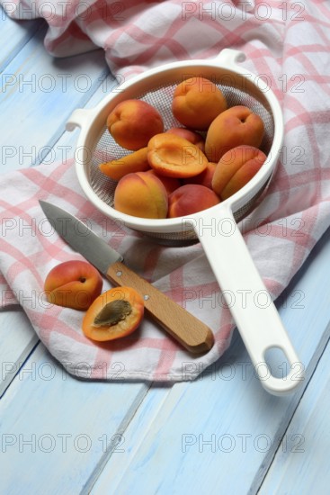 Apricots in colander, halved, Prunus armeniaca