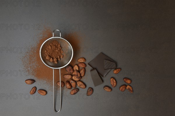 Kitchen sieve with cocoa powder and chocolate, cocoa and cocoa beans