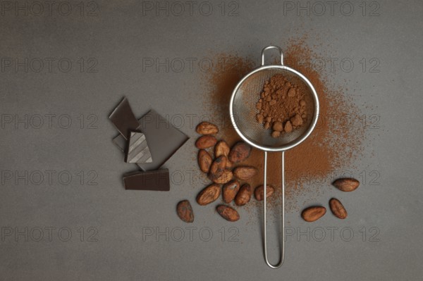 Kitchen sieve with cocoa powder and chocolate, cocoa and cocoa beans