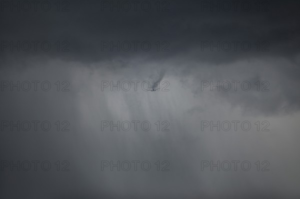 Aircraft breaks through cloud cover and drags a visible wake of vortices behind it