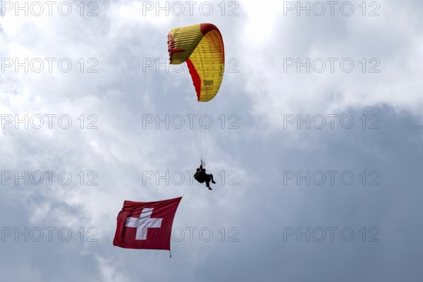 Paragliding tandem flight with Swiss flag, Interlaken, Switzerland
