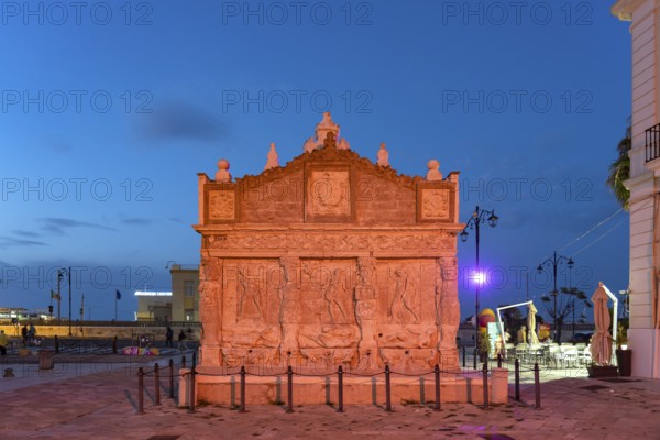The colourfully illuminated Greek fountain Fontana Greca at dusk, Gallipoli, Apulia, Italy