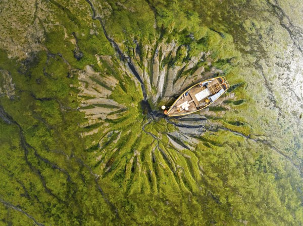 Top Down over boat and mud from drone, Paulsgrove Lake, Portchester Castle, Portchester, Fareham, Hampshire, England, United Kingdom