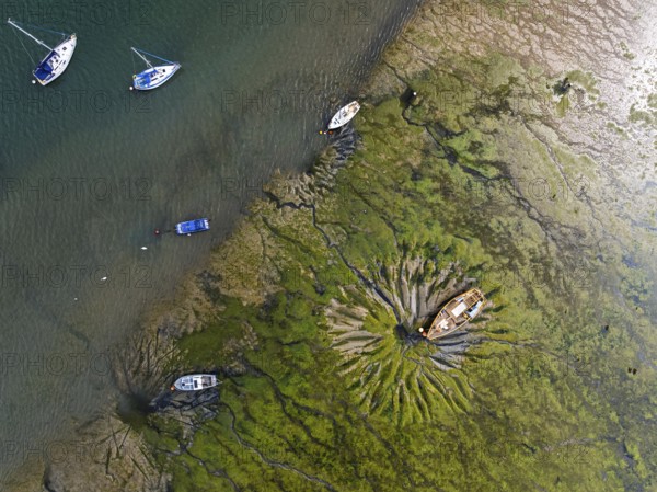 Top Down over boat and mud from drone, Paulsgrove Lake, Portchester Castle, Portchester, Fareham, Hampshire, England, United Kingdom