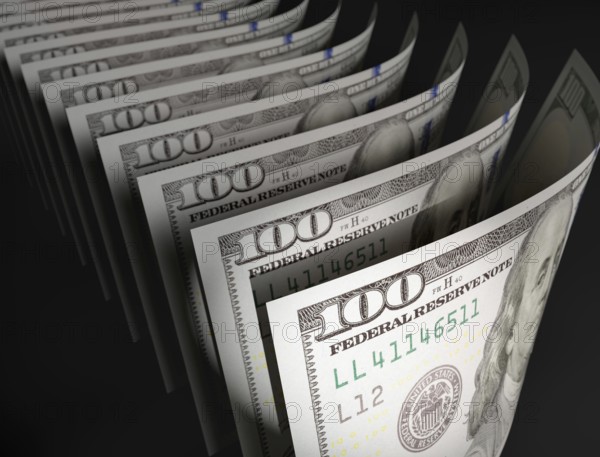 Spot lit abstract close-up angle of U.S. 100 dollar bills isolated on a black background