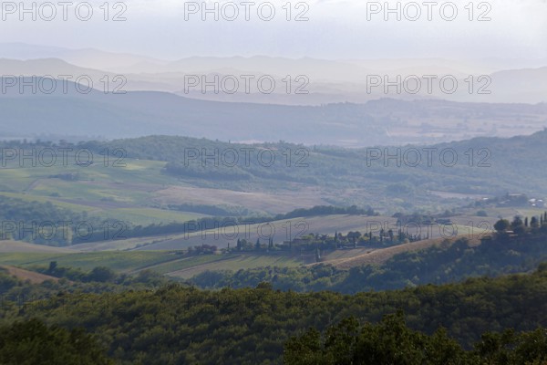 Hilly Tuscan landscape under a cloudy sky, wide open spaces and fields
