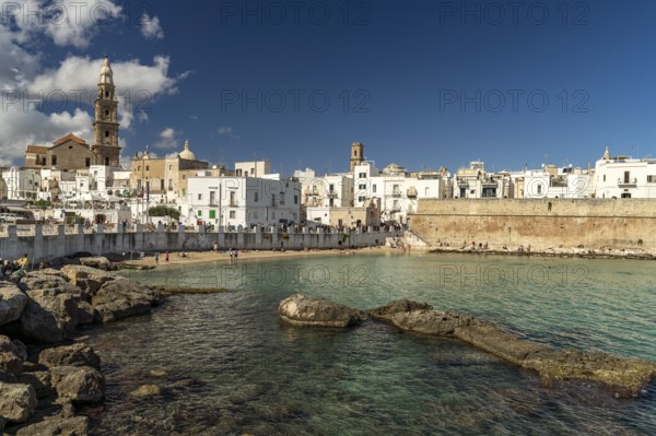 City view of Monopoli with the cathedral, city wall and the beach Cala Porta Vecchia, Apulia, Italy