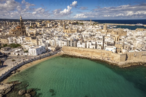 Old town of Monopoli with the cathedral, city walls and Cala Porta Vecchia beach seen from above, Apulia, Italy