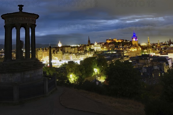 Night view of Edinburgh with illuminated buildings and a historical monument in the foreground, Old Town, Calton Hill, Edinburgh, Scotland, United Kingdom