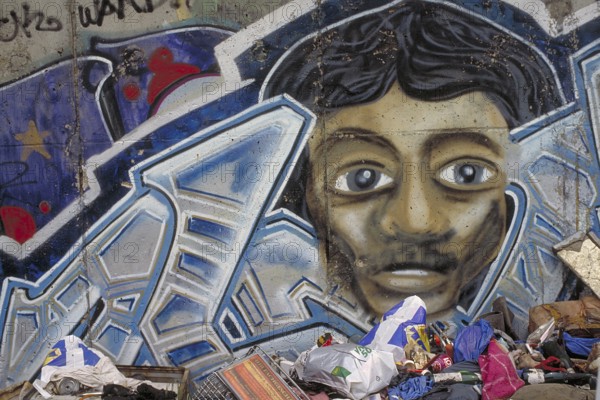 Painting created at the Berlin Wall in the 1990s, rubbish in front of the Wall, Berlin, Germany