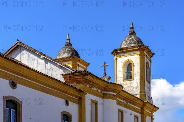 Tower and crucifix of a historic baroque church in the city of Ouro Preto in Minas Gerais, Ouro Preto, Minas Gerais, Brazil