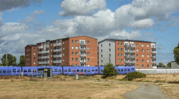 Modern apartment building built in 2020. A train passes by. Iin Ystad, Skåne County, Sweden, Scandinavia